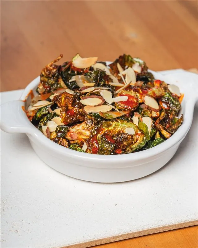 Crispy brussels sprouts with sliced almonds in sweet chili glaze
