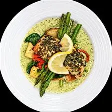 Herb Crusted Salmon in pesto cream sauce with spinach, roasted peppers, potatoes, and asparagus at BLVD Grille